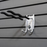 Multi-purpose tool hook on slatwall holding various items