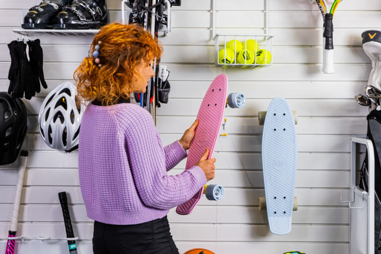 woman taking a penny board off flexipanel white slatwall